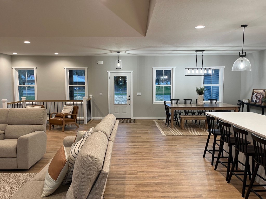 Open-concept great room with kitchen island, dining area, and living space
